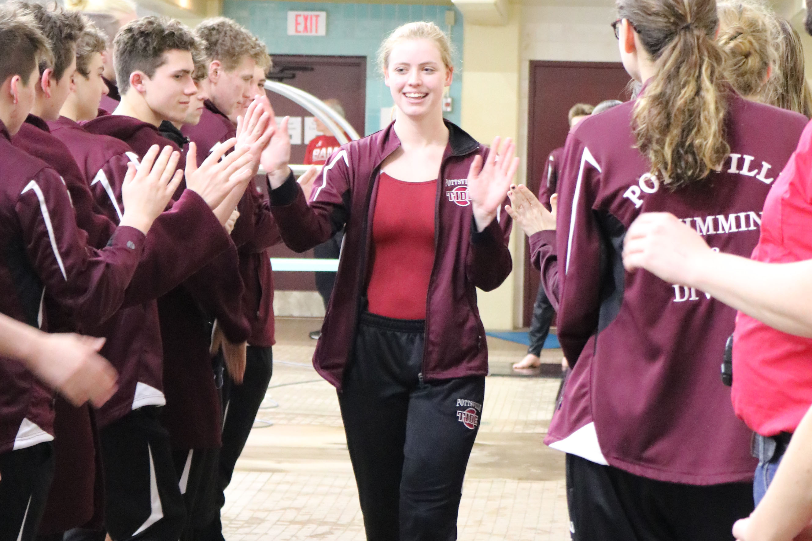 Walking down the aisle aisle formed by her teammates, senior Sarah Corse-Campion receives high fives on senior night. Senior night was held January 31 against Mahanoy Area. “I will miss everything about high school swimming, especially bonding with my best friends,” Corse-Campion said.