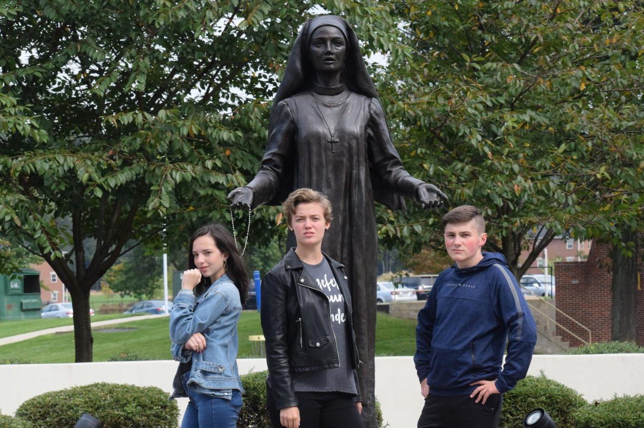 In front of a statue of Jane Frances de Chantal, sophomores Lily McDonald, Kendra Speak, and Jake Montgomery pose for the camera. The Drama Club, Stage Crew, and Dramatic Literature class went on a field trip to DeSales University to watch a Shakespeare play. “It was nice to see profesional actors so we can learn from them and do better. The show was good and fresh,” Autumn McDonough, senior said.