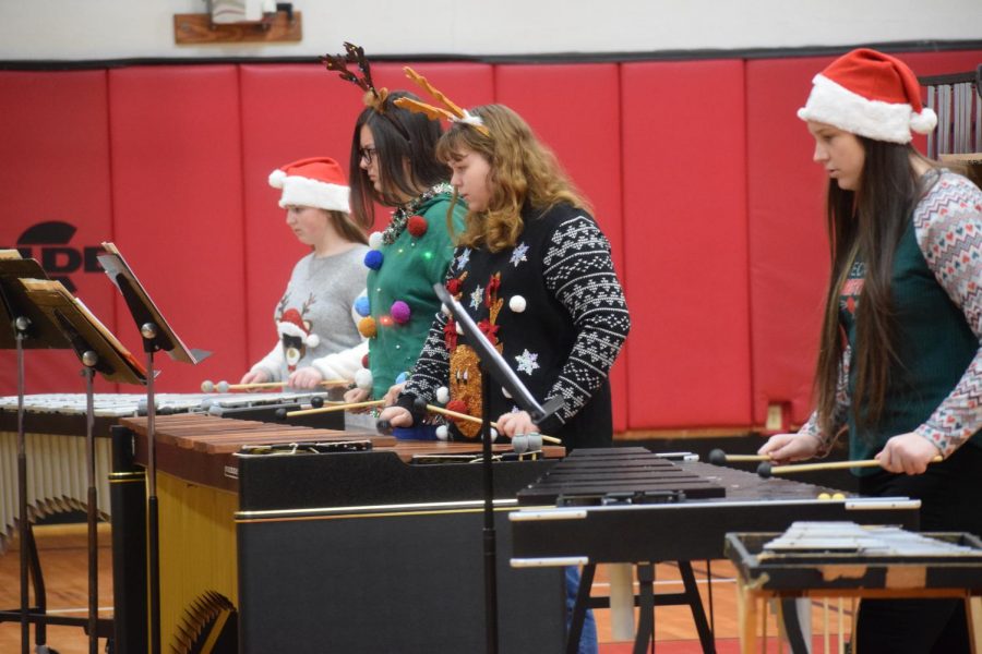 Victoria+Oswald+and+musicians+play+for+students+at+JSC.+The+ensemble+members+put+on+festive+clothing+and+played+Christmas+music+for+third+and+fourth+grade+students.+Junior+Wesley+Evans+said%2C+%22I+enjoyed+going+down+to+the+elementary+school+to+see+some+of+my+old+teachers+and+play+for+the+little+kids.%22+