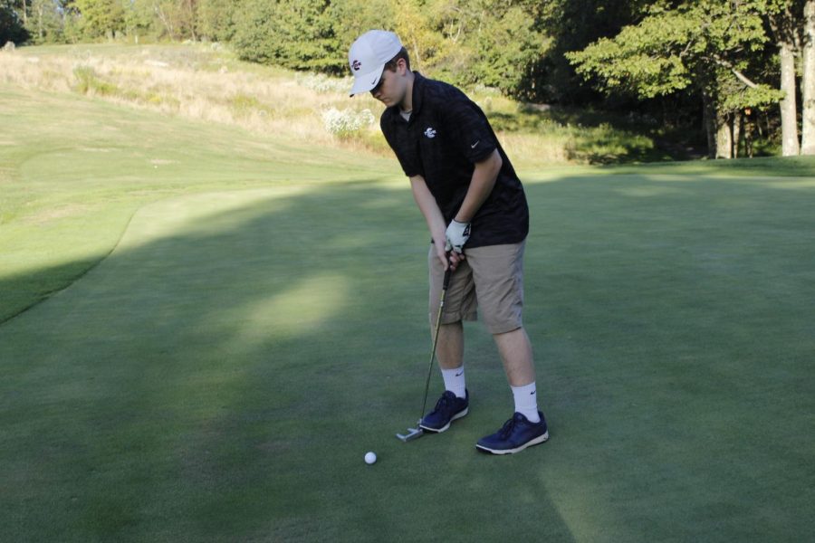 Junior+David+Troutman+is+preparing+to+hit+the+ball.+He+wanted+to+make+it+into+the+hole+to+help+his+team.+%E2%80%9CI+want+to+focus+and+try+my+best+on+all+18+holes%2C%E2%80%9D+said+Troutman%E2%80%99s+teammate%2C+Dominick+Chiccini.+