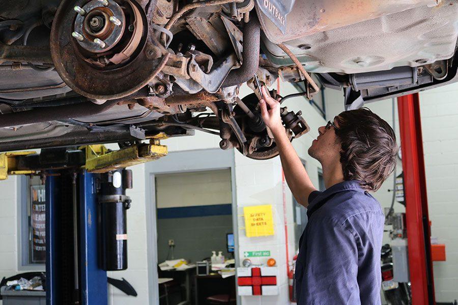 OBSERVE+%E2%80%93+Checking+out+the+underside+of+a+Subaru+Outback%2C+senior+Dakota+Butler+tightens+a+nut+on+an+extension+of+the+engine.+Butler+had+to+take+a+car+engine+totally+apart+and+put+it+back+together+for+one+of+his+project+grades.+%E2%80%9CI+decided+to+go+to+STC+because+I+wanted+to+learn+about+mechanics+and+I+like+to+work+on+cars.+I+specifically+like+to+work+on+engines%2C%E2%80%9D+Butler+said.+%E2%80%9CIt%E2%80%99s+the+hands-on+experience+that+really+helps.%E2%80%9D