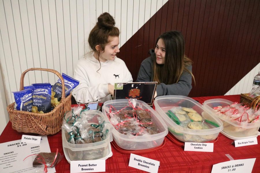 HELPING+-+Seniors+Kalie+Tobin+and+Matilyn+Ashfield%2C+Sketch+Club+members%2C+volunteer+their+time+to+manage+the+refreshments+at+the+Family+Paint+Nite.+The+PASD+art+department+raised+enough+money+to+cover+the+cost+of+art+supplies+for+the+rest+of+the+school+year.+%E2%80%9CI+really+enjoyed+helping+out.+I+feel+like+these+events+bring+the+community+together.+I+would+volunteer+again.+I+think+it+is+a+good+thing+to+do+for+the+school%2C%E2%80%9D+senior+Kalie+Tobin+said.